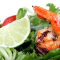 grilled shrimp over greens with lime wedge