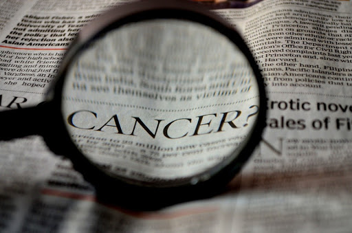 newspaper and magnifying glass on cancer